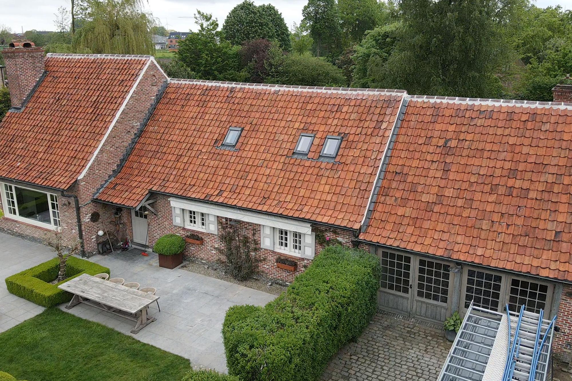 Afgewerkt hellend dak met rode dakpannen en dakramen